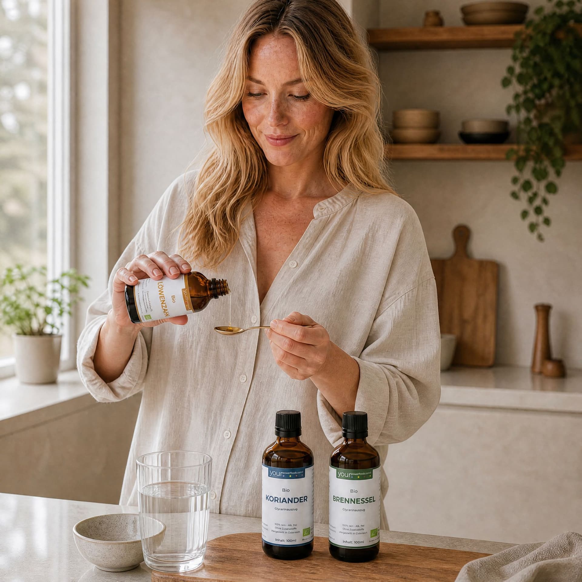 Detox Balance Bundle – Frau in heller Küche dosiert Tropfen aus Braunglasflasche auf Löffel, zwei weitere Flaschen mit Korian